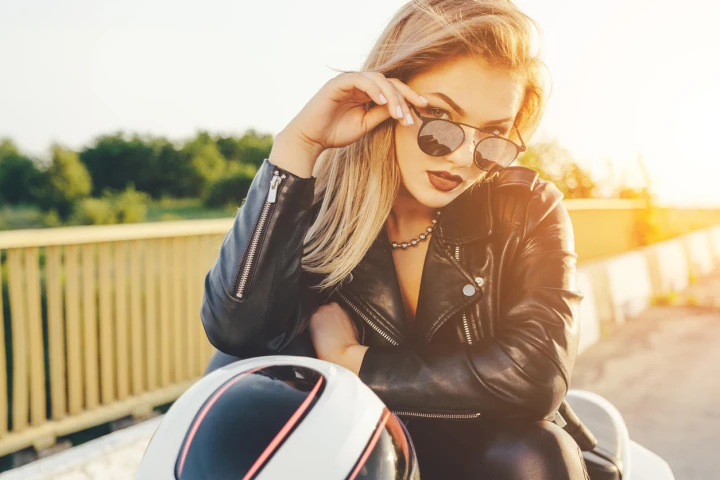 Blonde Frau in Bikerjacke auf einem Motorrad