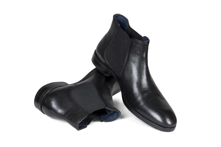 Schwarze Chelsea Boots auf weißem Hintergrund platziert