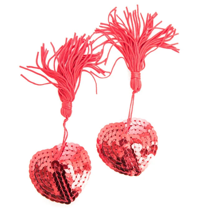 Zwei rote glitzernde Pasties zur Bedeckung der weiblichen Brustwarzen und des Intimbereiches. 