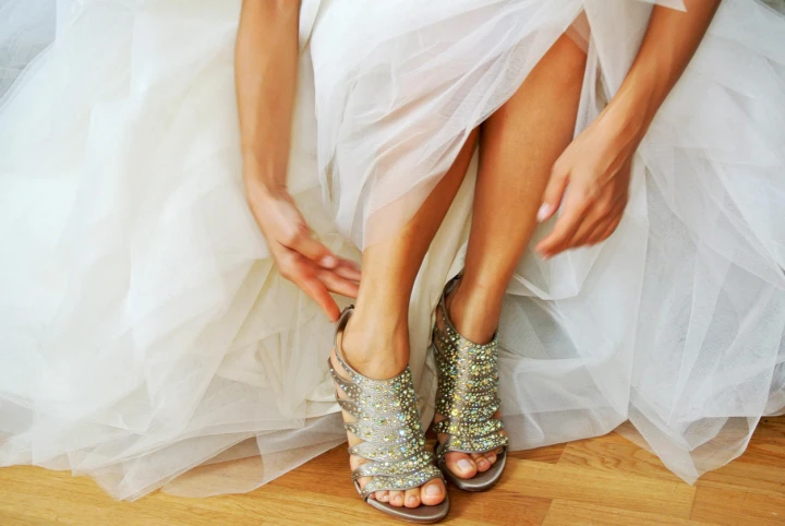 Braut in einem Kleid aus Organze und goldenen High Heels