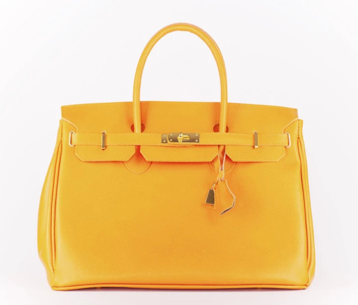 Orange Kelly Bag auf weißem Hintergrund. 