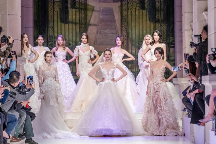 Mehrere Models präsentieren Haute Couture-Brautkleider auf einem Laufsteg. 