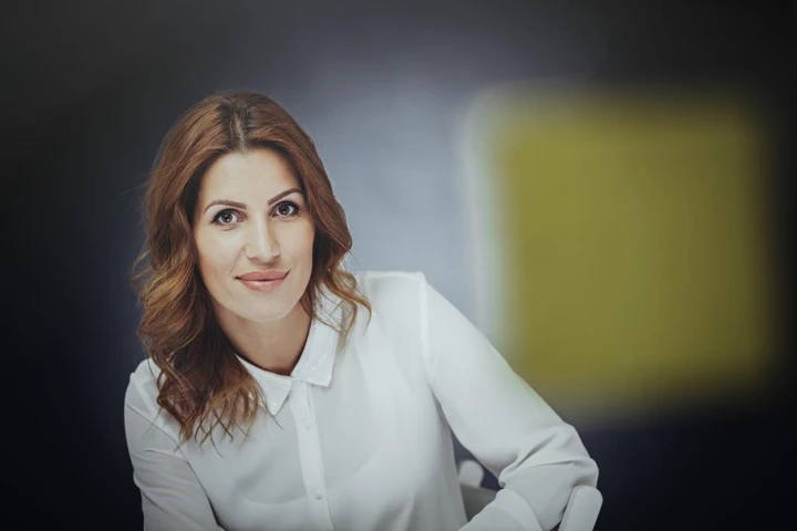 Selbstbewusste Frau mit hellbraunen Haaren und weißem Hemd im minimalistischen Style.. 